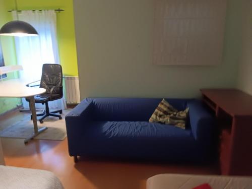 a living room with a blue couch and a table at Global Guest Rooms in Sintra