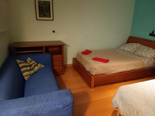 a bedroom with a bed and a blue couch at Global Guest Rooms in Sintra