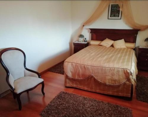 a bedroom with a bed and a chair in it at Global Guest Rooms in Sintra