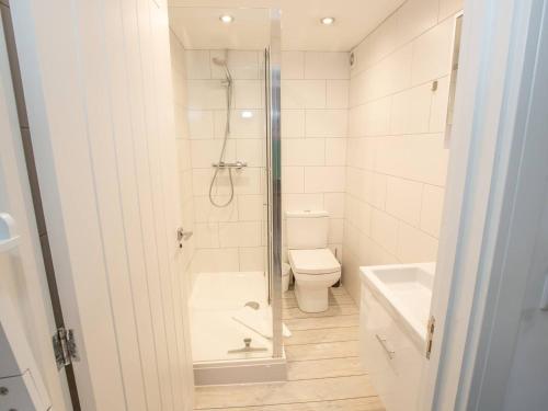 a white bathroom with a shower and a toilet at Pass the Keys Stylish apartment in peaceful Oxfordshire suburb in Kidlington