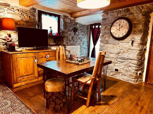 une salle à manger avec une table et une horloge au mur dans l'établissement Maison Bovet, à La Salle