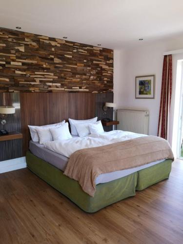 a bedroom with a large bed with a wooden wall at Hotel Almrausch in Bad Reichenhall