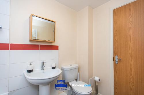 a bathroom with a toilet and a sink and a mirror at Two Bedroom Apartment By Beds Away Short Lets & Serviced Accommodation Close to Kidlington Airport and Blenheim Palace in Kidlington