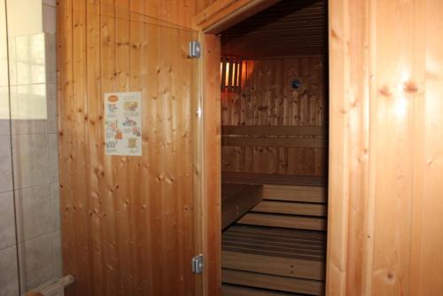 an empty sauna with a wooden wall and stairs at Villa Jagdhaus in Wernigerode