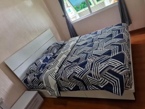a bed with blue and white sheets and a window at Town House MGR 2, Central Park Mall Area, Pool Side-1st floor in Jakarta