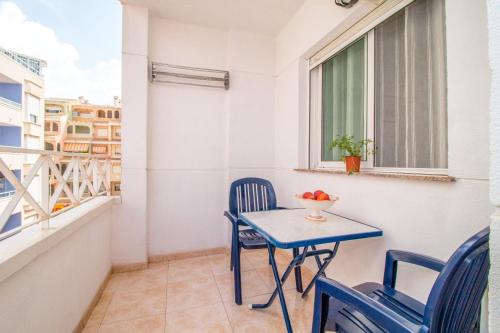 a small blue table and chairs on a balcony at Parque De Las Naciones Dragon con garaje ! in Torrevieja