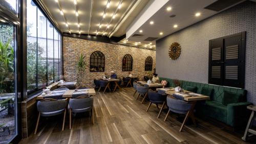 una sala da pranzo con tavoli, sedie e un muro di mattoni di Mai İnci Otel a Antalya (Adalia)