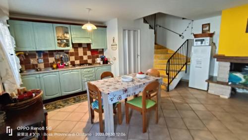 a kitchen with a table and chairs and a staircase at Casa Allende in Bosa