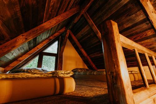 um quarto com uma cama num sótão de madeira em RelaxLak 