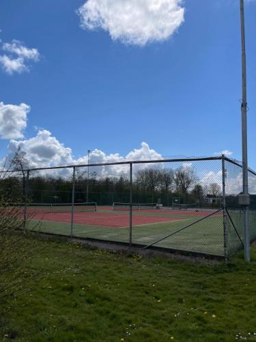 a tennis court with two tennis courts at It Fugelnest in Tzummarum