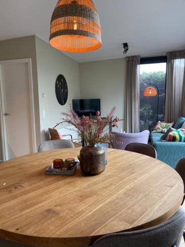 a wooden table with a vase of flowers on it at It Fugelnest in Tzummarum