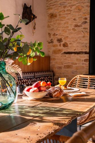 einen Tisch mit einer Schale Obst und einem Teller Essen in der Unterkunft Domaine Villoire in Cassagnes
