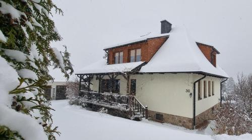 Una casa con nieve en el techo. en Mountain House, en Ustrzyki Dolne