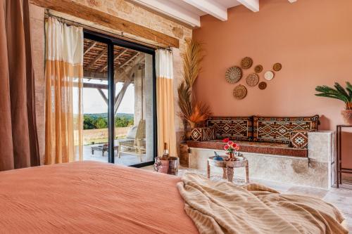 um quarto com uma cama e uma grande janela em Domaine Villoire em Cassagnes