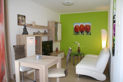 sala de estar con mesa y pared verde en Cloud 7 en Heinsberg