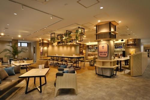 a restaurant with tables and couches and tables and chairs at Shin Toji Hotel Lulud in Nakanojo