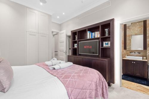 1 dormitorio con 1 cama y TV en la pared en St James Park and Westminster Luxury Suite en Londres