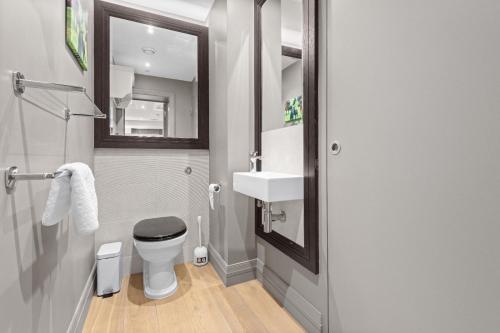 a bathroom with a toilet and a sink and a mirror at St James Park and Westminster Luxury Suite in London