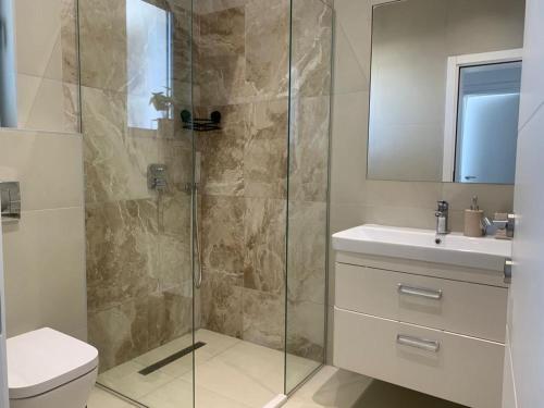 W łazience znajduje się prysznic, toaleta i umywalka. w obiekcie Luxury Villa Lorcrimar w mieście Masline