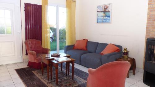 - un salon avec un canapé bleu et deux chaises dans l'établissement Charmante maison de village à 5 min de la rivière du Bono, à Plougoumelen