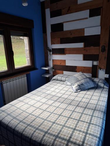a bedroom with a bed and a wooden headboard at Pensión Casaño in Arenas de Cabrales