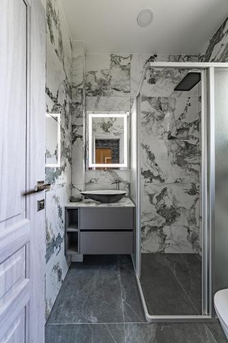 a bathroom with a sink and a shower at Zalesossodyba in Purnuškis