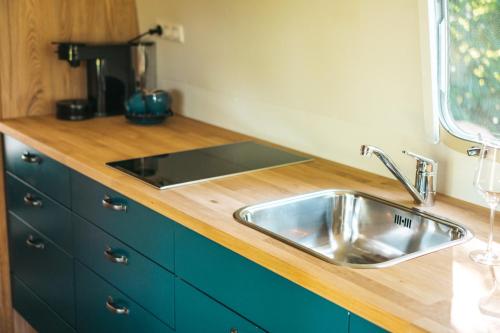 a kitchen with a sink and a wooden counter top at Glamping aan de Maas in Kessel
