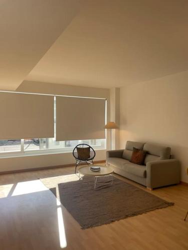 a living room with a couch and a table at Soho Moraleja III in Alcobendas