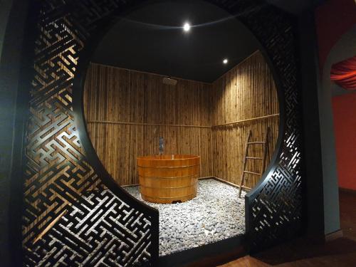 a room with a wooden wall with a wooden tub at Language Exchange Hotel 3 in Ho Chi Minh City