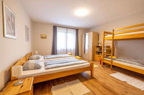 VasvárにあるBoglárka Vendégházのベッドルーム1室(大型ベッド1台、二段ベッド2組付)