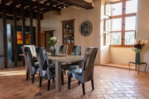 uma sala de jantar com uma mesa de madeira e cadeiras em Manoir de la coudre em Changé