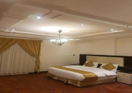 Schlafzimmer mit einem Bett und einem Kronleuchter in der Unterkunft حياة ريف للوحدات السكنية المفروشة in Dschidda