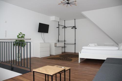 a white living room with a bed and a table at Nibelungen Apartments - Hantalgasse Worms in Worms