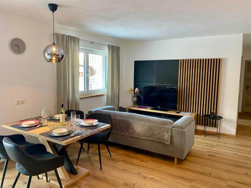 una sala de estar con un sofá y una mesa en Apartment Bergfieber, en Fieberbrunn