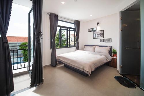 a bedroom with a bed and a large window at Marina Hoian Villa in Hoi An