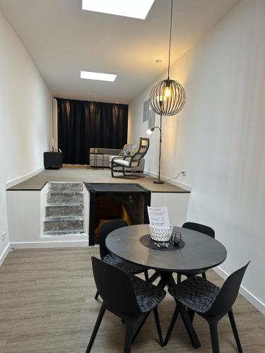 a living room with a table and chairs and a fireplace at luxe pas gerenoveerd monumentaal appartement in Maastricht