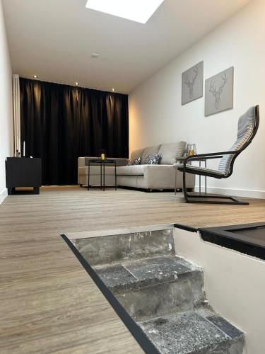 a living room with a couch and a chair at luxe pas gerenoveerd monumentaal appartement in Maastricht