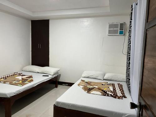 a room with two beds in a room at Jancas Vacation Home Camiguin Family Room in Catarman