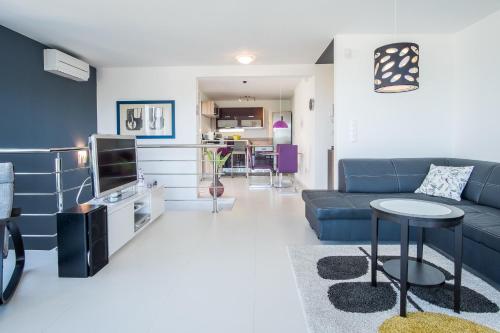 a living room with a blue couch and a tv at Luxury Spa Apartment Luna in Njivice