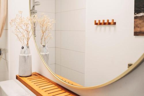 a bathroom with a mirror and two vases on a bench at Urlaub an der Flensburger Förde mit Sauna & schönem Ambiente in Flensburg