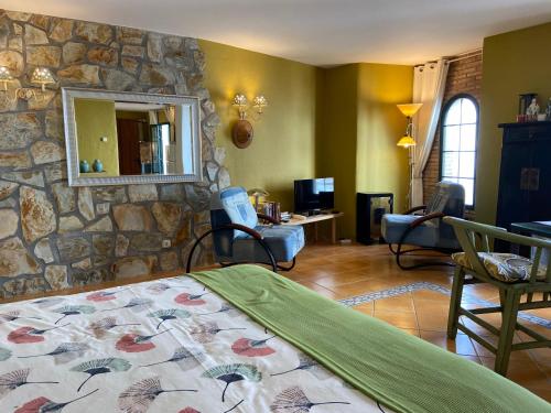 コンペタにあるCompeta Suitesの石壁のベッドルーム(ベッド、椅子付)