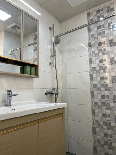 uma casa de banho com um lavatório e um chuveiro em Vientiane city center modern apartment em Vientiane