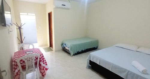 um quarto com 2 camas, uma mesa e uma cadeira em Francisca e Manoel em Boa Vista