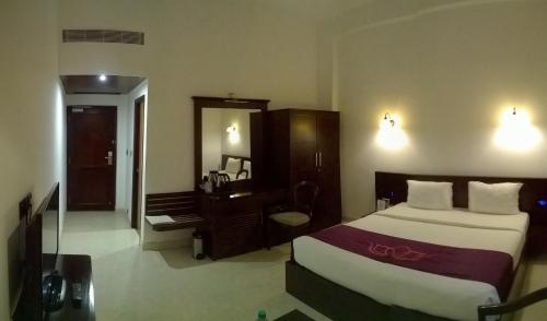 Una cama o camas en una habitación de Lakshmi Hotel