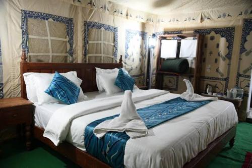 a bedroom with a large bed with towels on it at Thar Accent Hostel in Jaisalmer