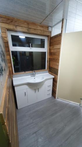 baño con lavabo y ventana en The Fox Pod at Nelson Park Riding Centre Ltd GLAMPING POD Birchington, Ramsgate, Margate, Broadstairs, also available we have the Pony Pod and Trailor Escapes converted horse box en Birchington