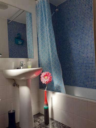 a bathroom with a sink and a vase with a flower in it at Apartamento Burgo " A Preferida " in Funchal