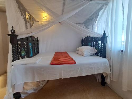 sypialnia z łóżkiem z baldachimem w obiekcie pilipili bed house w mieście Lamu