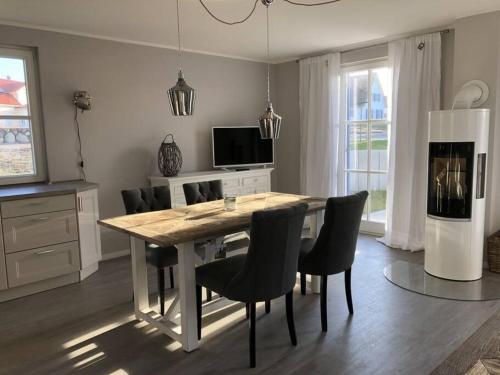 a kitchen with a dining room table and chairs at Reetdachhaus Seasons mit Kamin & Sauna in Groß Schwansee