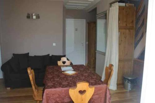 - un salon avec une table et un canapé noir dans l'établissement Superbe appartement vue montagne, à Saint-Étienne-de-Tinée